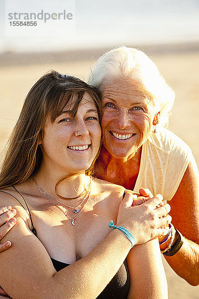 Porträt von Mutter und erwachsener Tochter lächelnd am Strand
