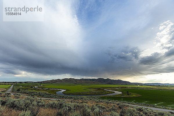 Wolkenlandschaft über einem Fluss durch Felder in Picabo  Idaho  USA