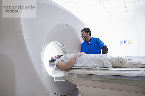 Junger männlicher Radiologe am CT-Scanner in der radiologischen Abteilung