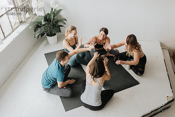 Freunde machen High Five im Yoga-Studio