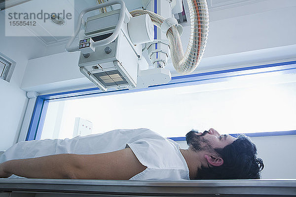 Junger männlicher Patient mit einem CT-Scan in der radiologischen Abteilung  Seitenansicht