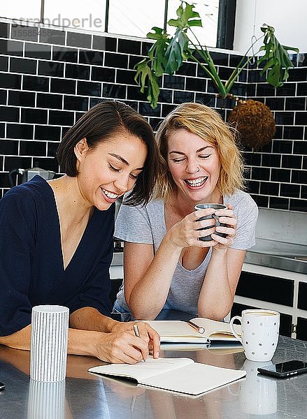 Kollegen sprechen und arbeiten in der Kaffeepause in der Speisekammer