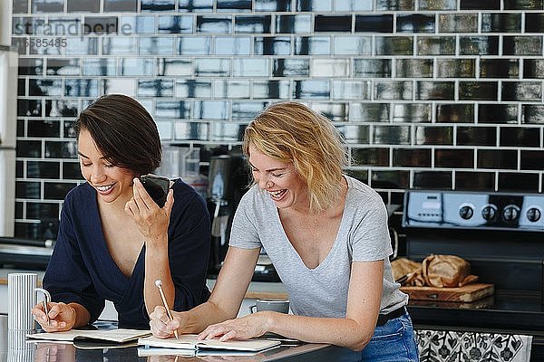 Kollegen sprechen und arbeiten in der Kaffeepause in der Speisekammer