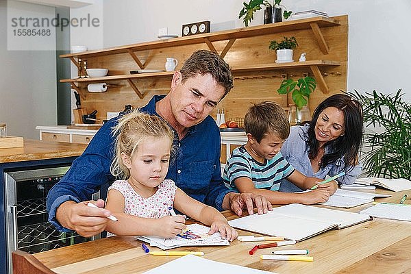 Eltern helfen Kindern zu Hause bei den Hausaufgaben