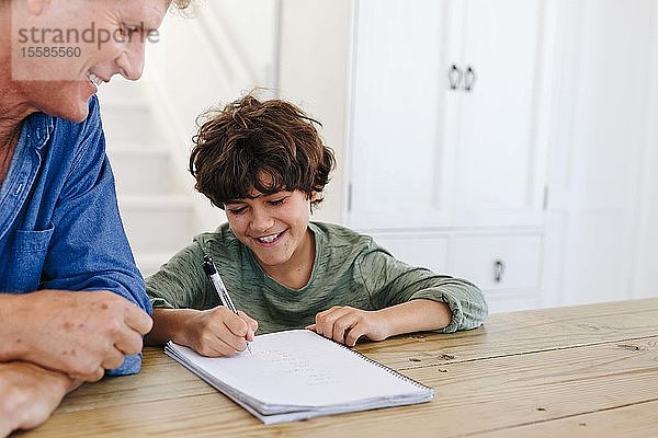 Vater hilft Sohn bei den Hausaufgaben zu Hause