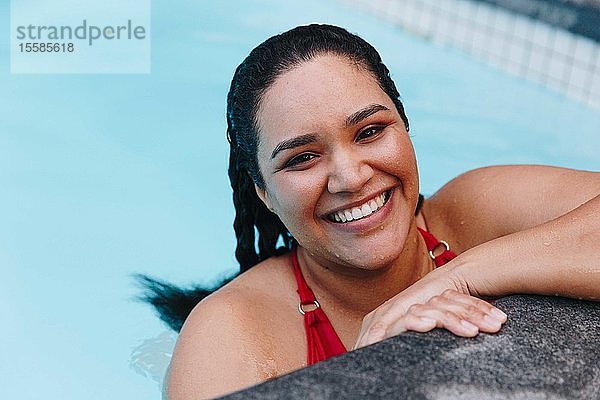 Mittelgroße erwachsene Frau mit nassem Haar  die am Swimmingpool im Freien ruht  Kopf- und Schulterporträt  Kapstadt  Südafrika