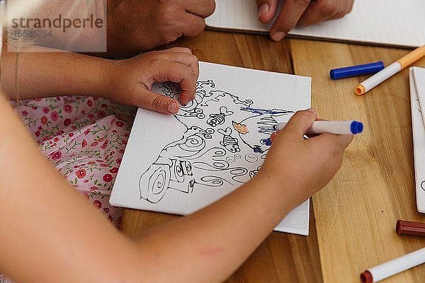 Kind malt ein Bild auf einem Tisch