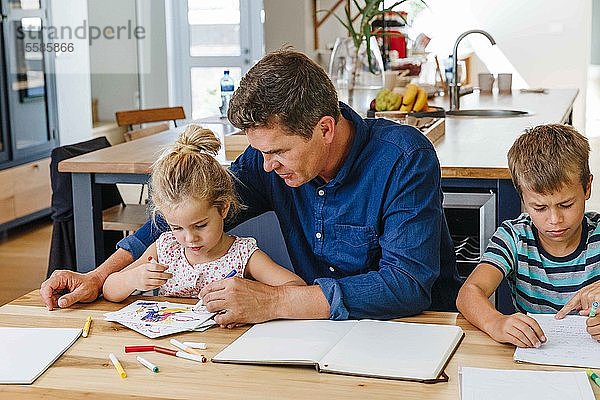 Eltern helfen Kindern bei den Hausaufgaben zu Hause