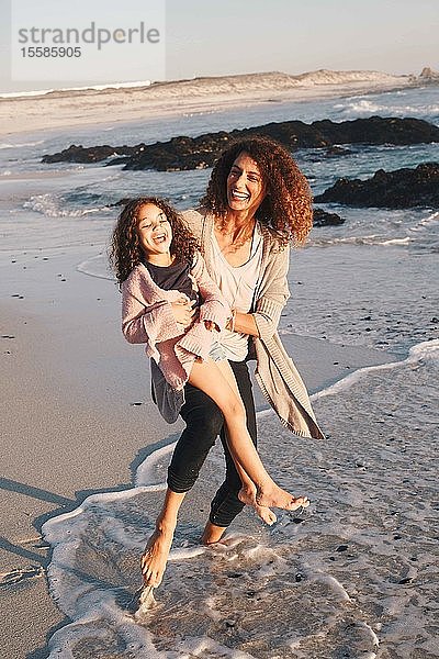 Mutter und Tochter spielen am Strand