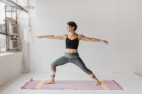 Frau praktiziert Yoga im Studio