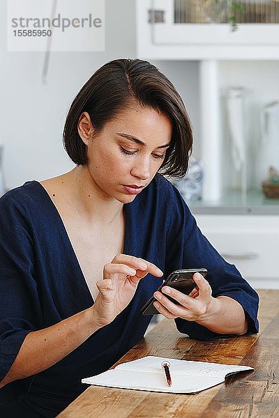 Geschäftsfrau benutzt Mobiltelefon im Büro