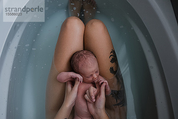 Mutter mit kleinem Sohn auf dem Schoß in der Badewanne  Draufsicht beschnitten