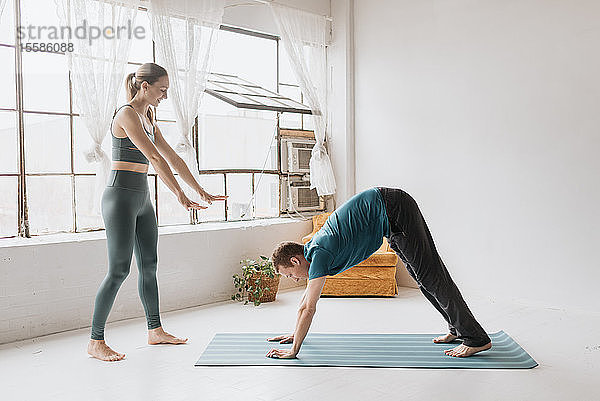 Yogalehrerin unterrichtet Yoga im Studio