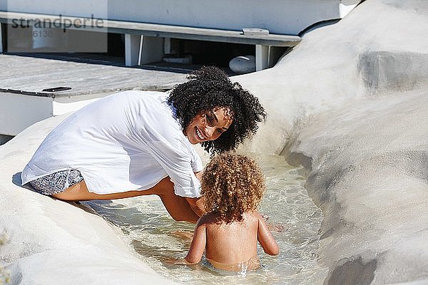 Mutter und Tochter spielen im künstlichen Schwimmbecken