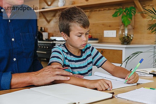 Vater hilft Sohn bei den Hausaufgaben zu Hause