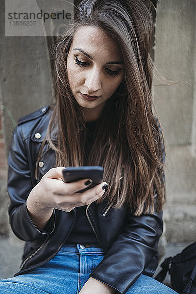 Frau benutzt Smartphone auf Stufen