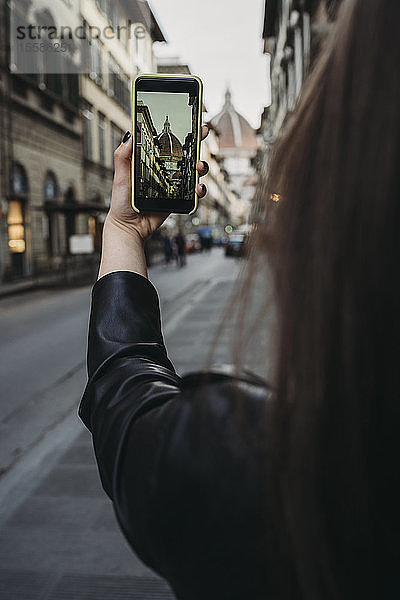 Frau fotografiert Gebäude in der Stadt