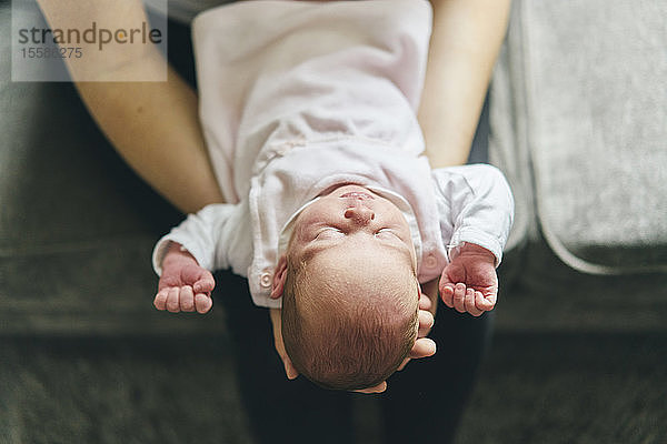 Mutter unterstützt Kopf des Babys auf dem Schoß