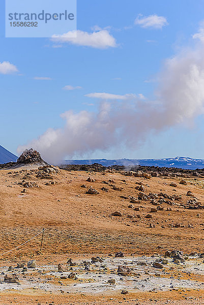 Hügellandschaft mit Felsformationen und aufsteigendem Dampf gegen blauen Himmel  Akureyri  Eyjafjardarsysla  Island