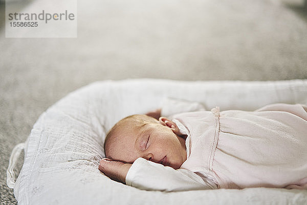 Baby schläft zu Hause auf einem U-förmigen Kissen