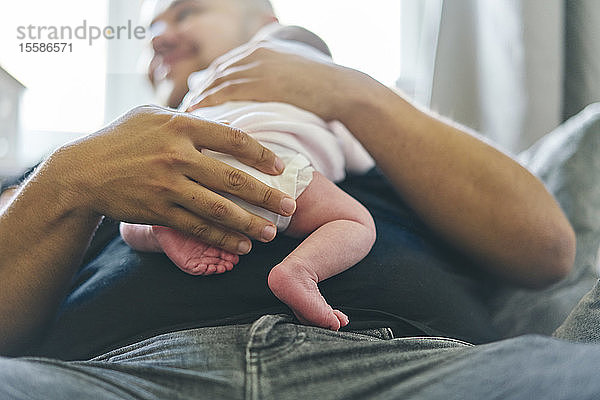 Baby ruht zu Hause auf der Brust des Vaters