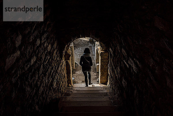 Frau  die in einem Steingebäude eine Treppe hinuntergeht  Izmir  Türkei