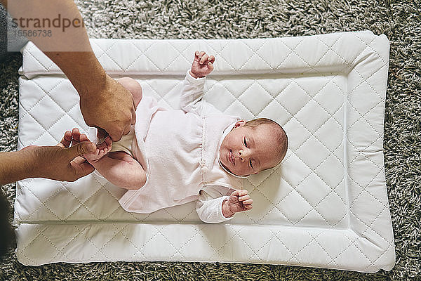 Vater wechselt die Windel des Babys zu Hause