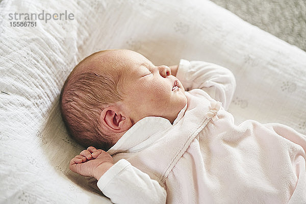 Baby schläft zu Hause auf einem U-förmigen Kissen