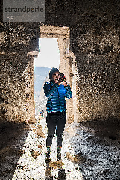 Frau beim Fotografieren im Kloster Selime  GÃ¶reme  Kappadokien  Nevsehir  TÃ?rkei