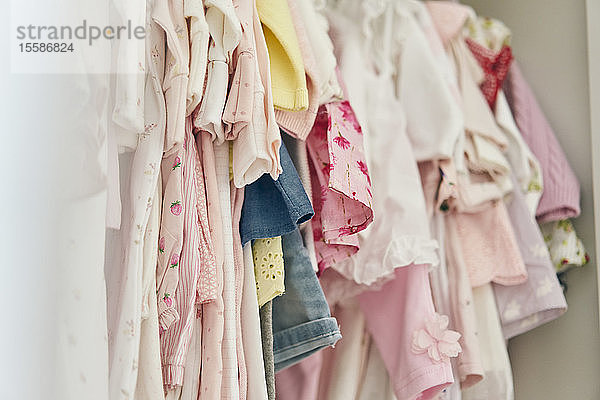 Sortiment an Babykleidung im Schrank aufgehängt