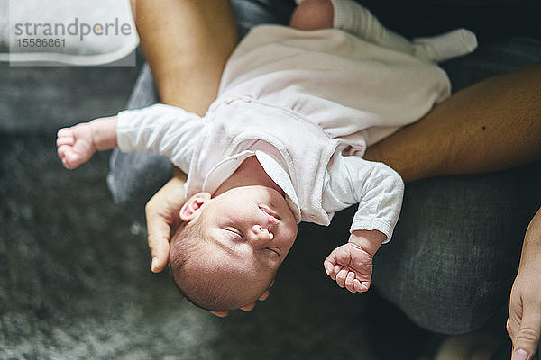 Vater unterstützt Kopf des Babys auf dem Schoß