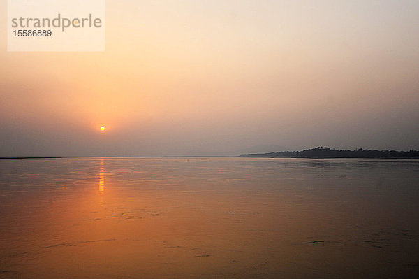Sonnenuntergang über den riesigen Gewässern des mächtigen Brahmaputra  Assam  Indien