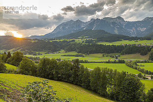 Blick auf einen vorbeifahrenden Zug und Sonnenuntergang über den Bergen um Oberhaus  Steiermark  Österreich