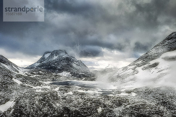 Gewitterwolken über dem See Olaskarsvatnet zu Füßen des schneebedeckten Berges Olaskarstind  Venjesdalen-Tal  Andalsnes  Norwegen  Skandinavien