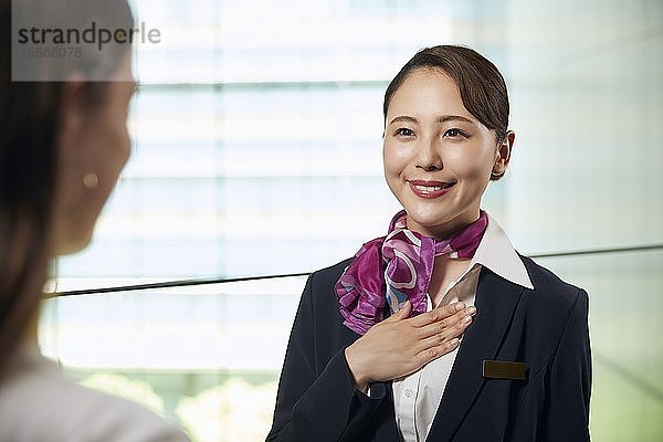 Japanische Flugbegleiterin hilft Kunden