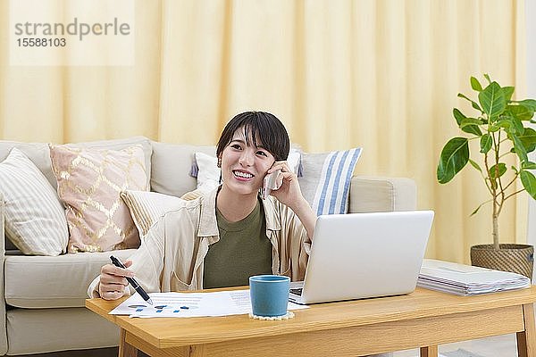 Junge japanische Frau bei der Arbeit zu Hause