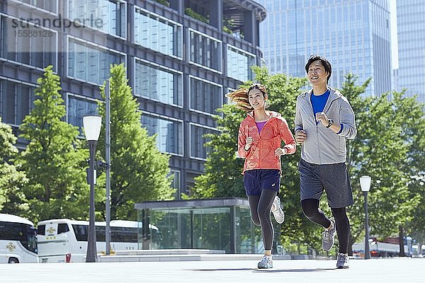 Junges japanisches Paar beim Laufen in der Innenstadt von Tokio