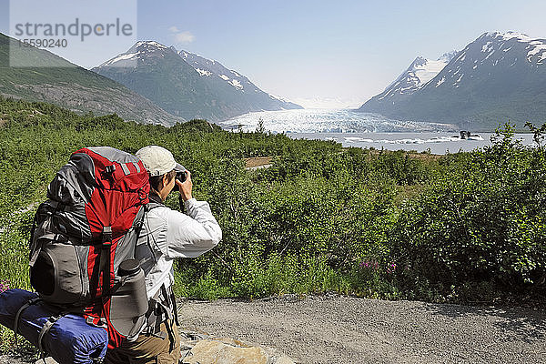 Weiblicher Wanderer hält für ein Foto entlang des Pfades zum Spencer Glacier an  Süd-Zentral-Alaska