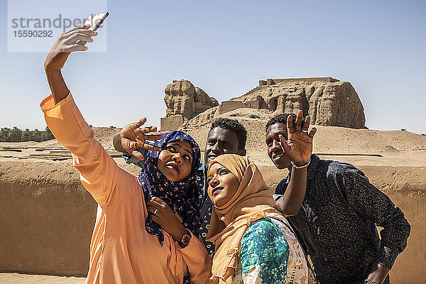 Sudanesische Studenten  die ein Selbstporträt mit einem Smartphone aufnehmen; Kerma  Nordstaat  Sudan