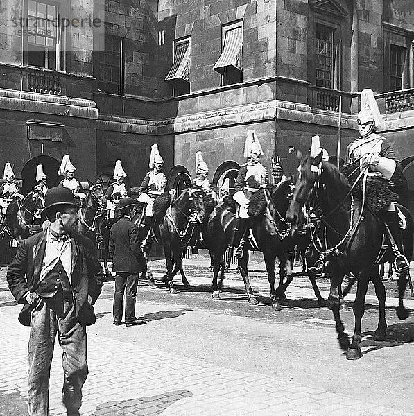 Diapositiv mit Laterna Magica  um 1880  viktorianisch/edwardianisch  Sozialgeschichte. Ein armer Mann auf der Straße geht an der Horse Guards Parade vorbei; London  England