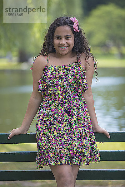 Porträt eines glücklichen hispanischen Mädchens mit Zahnspange im Park