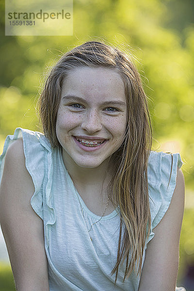 Porträt eines glücklichen hispanischen Teenager-Mädchens mit Zahnspange im Park