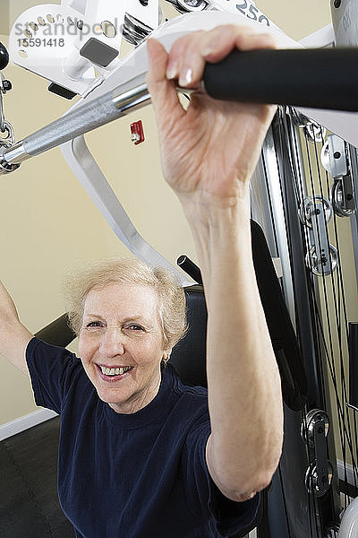 Porträt einer älteren Frau  die im Fitnessstudio trainiert.