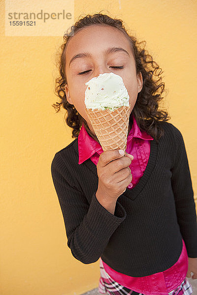 Hispanisches Mädchen isst ein Eis