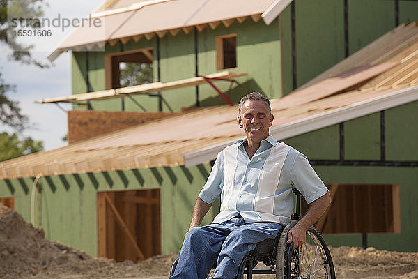 Ein querschnittsgelähmter Mann im Rollstuhl in seinem neuen  im Bau befindlichen barrierefreien Haus