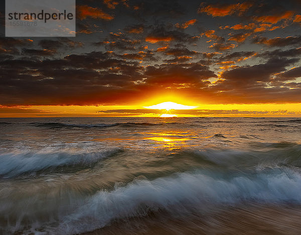 Heller  goldener Sonnenaufgang über Strand und Meer; Kauai  Hawaii  Vereinigte Staaten von Amerika