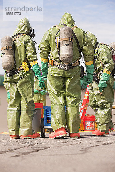 Rückansicht von HazMat-Feuerwehrleuten mit Atemluftflaschen