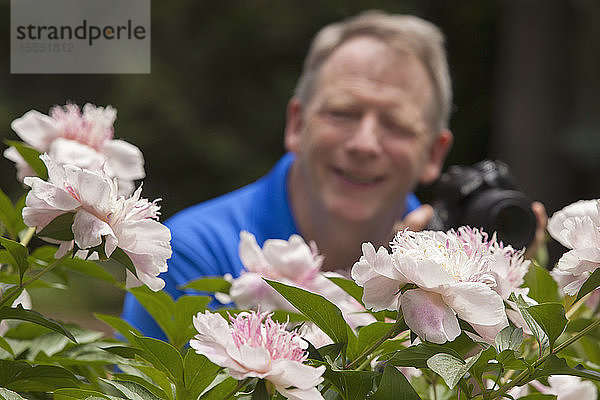 Mann mit zerebraler Lähmung und Legasthenie fotografiert seine Blumen