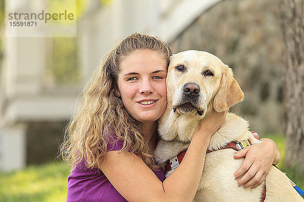 Frau mit Sehbehinderung umarmt ihren Diensthund