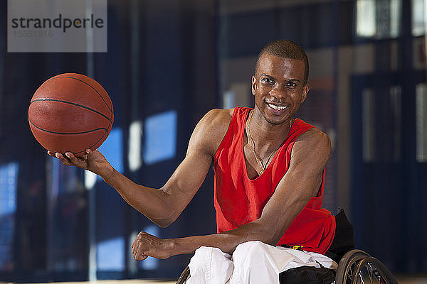 Mann mit Spinaler Meningitis im Rollstuhl hält Basketball